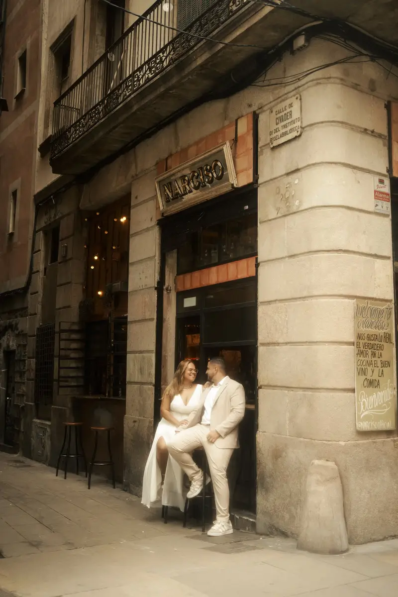 Os dois sentados juntos na entrada iluminada de um bar antigo, de frente um para o outro