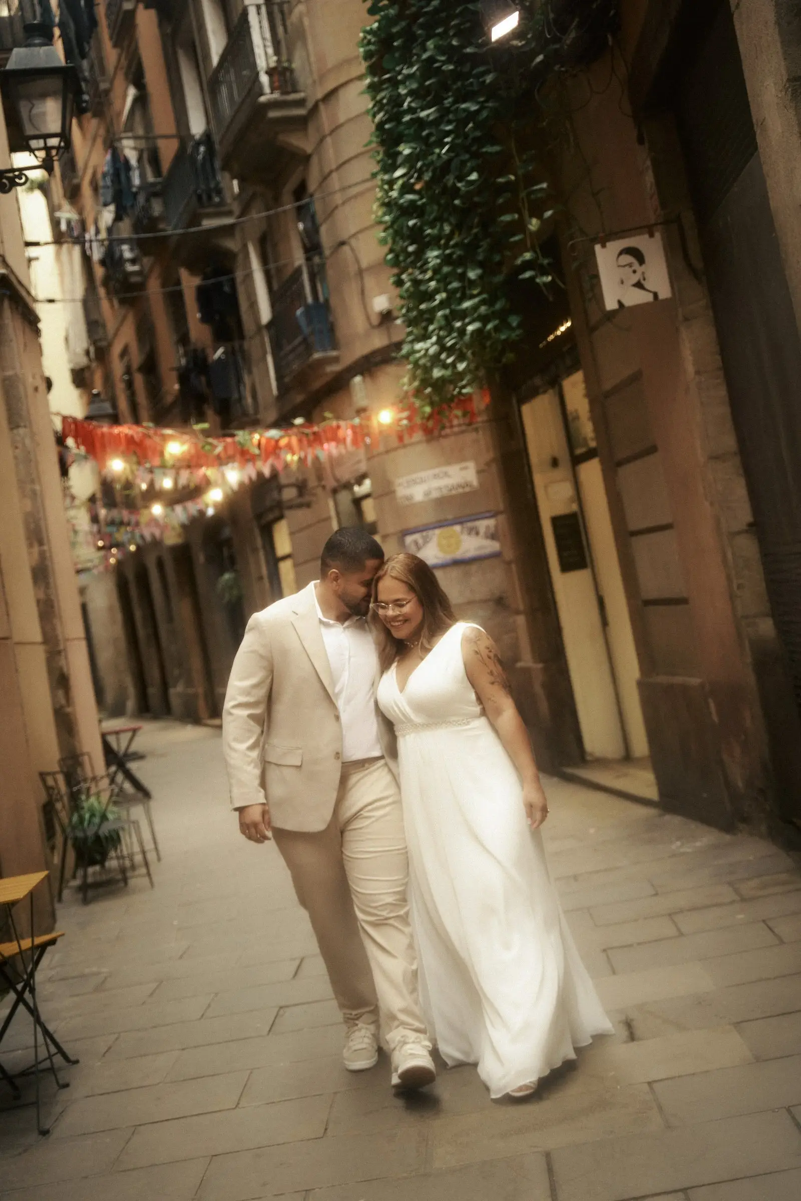 O casal abraçado sob luzes penduradas ao entardecer