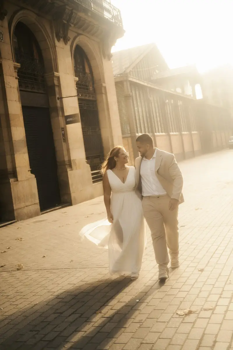 O casal caminhando abraçado numa rua tomada por luz dourada de fim de tarde