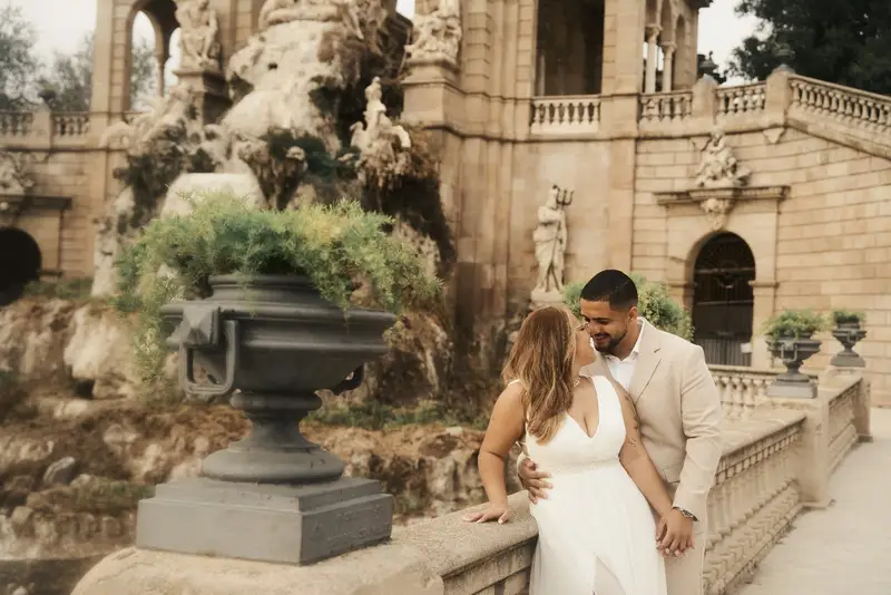 Gisele e Victor apoiados na mureta de pedra da fonte, olhando um para o outro